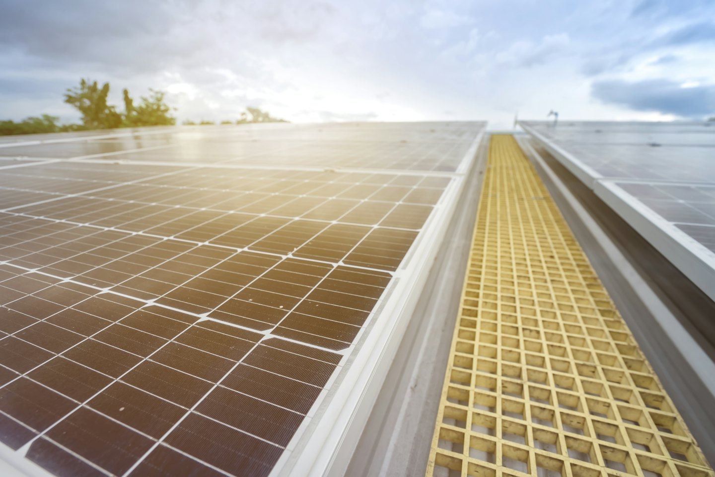 Paneles solares instalados en un tejado con pasarela amarilla.